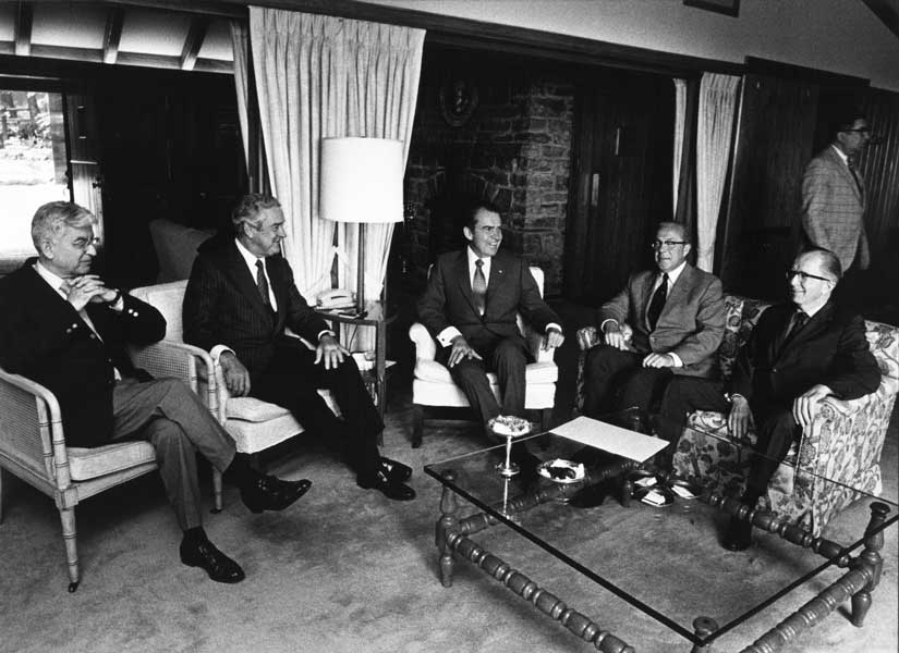 President Nixon sits with economic policy advisors at Camp David including Chairman of the Board of Governors of the Federal Reserve System Arthur Burns.