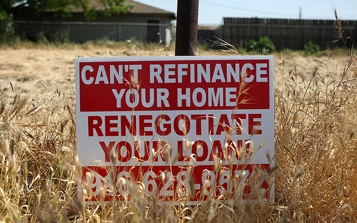 A sign advertising refinancing services is posted in a vacant lot April 29, 2008, in Stockton, California.