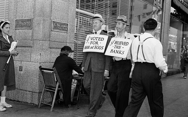 Men wearing sandwich boards reading "I voted for ham and eggs" and "I believed the banks" walk down a Los Angeles street,&nbsp;Oct. 24, 1938.&nbsp;