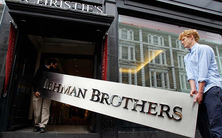 Two men carry the Lehman Brother’s corporate sign to an auction house in London.